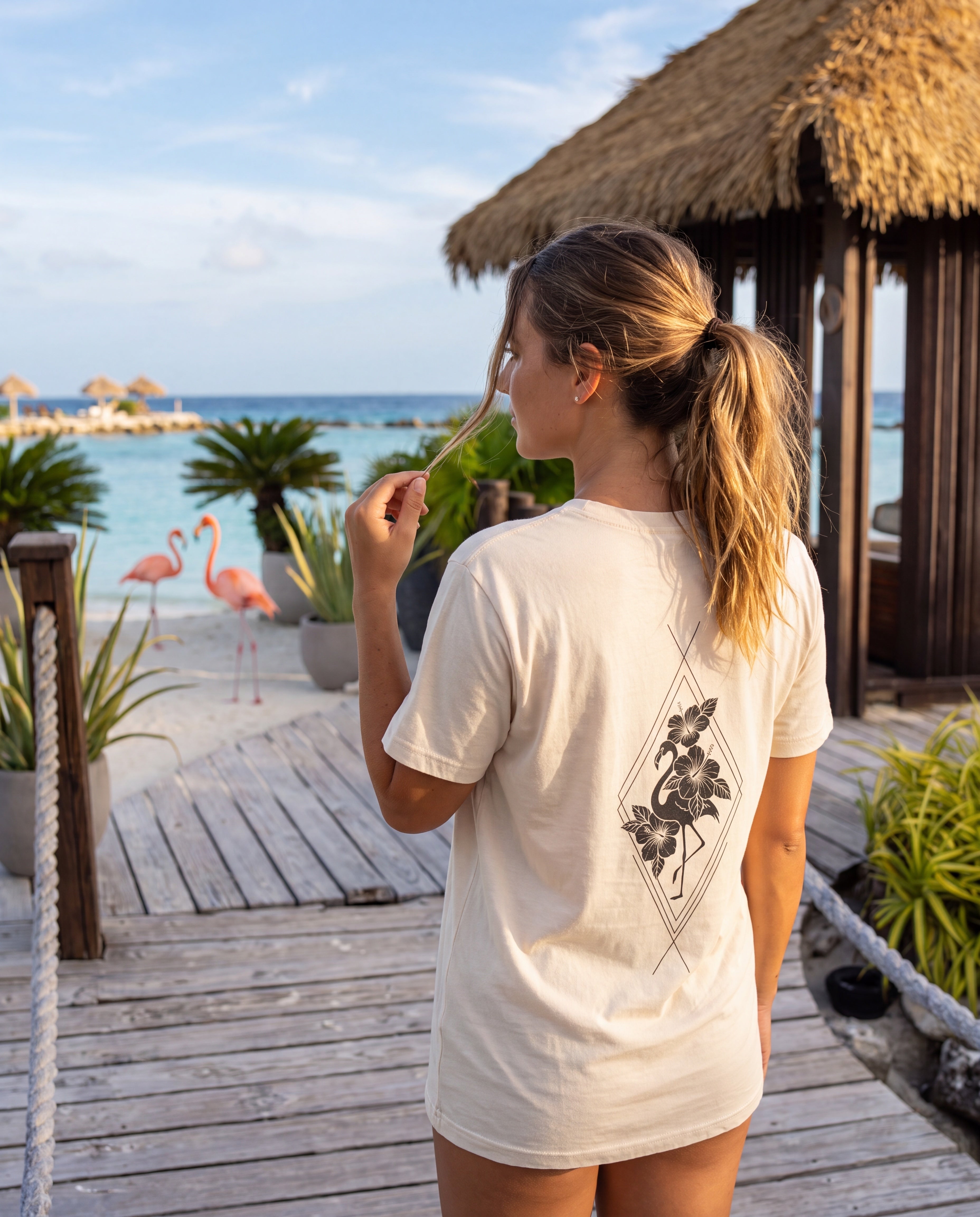 Woman wearing the Aruba Flamingo and Hibiscus Tee at Flamingo Beach, Aruba