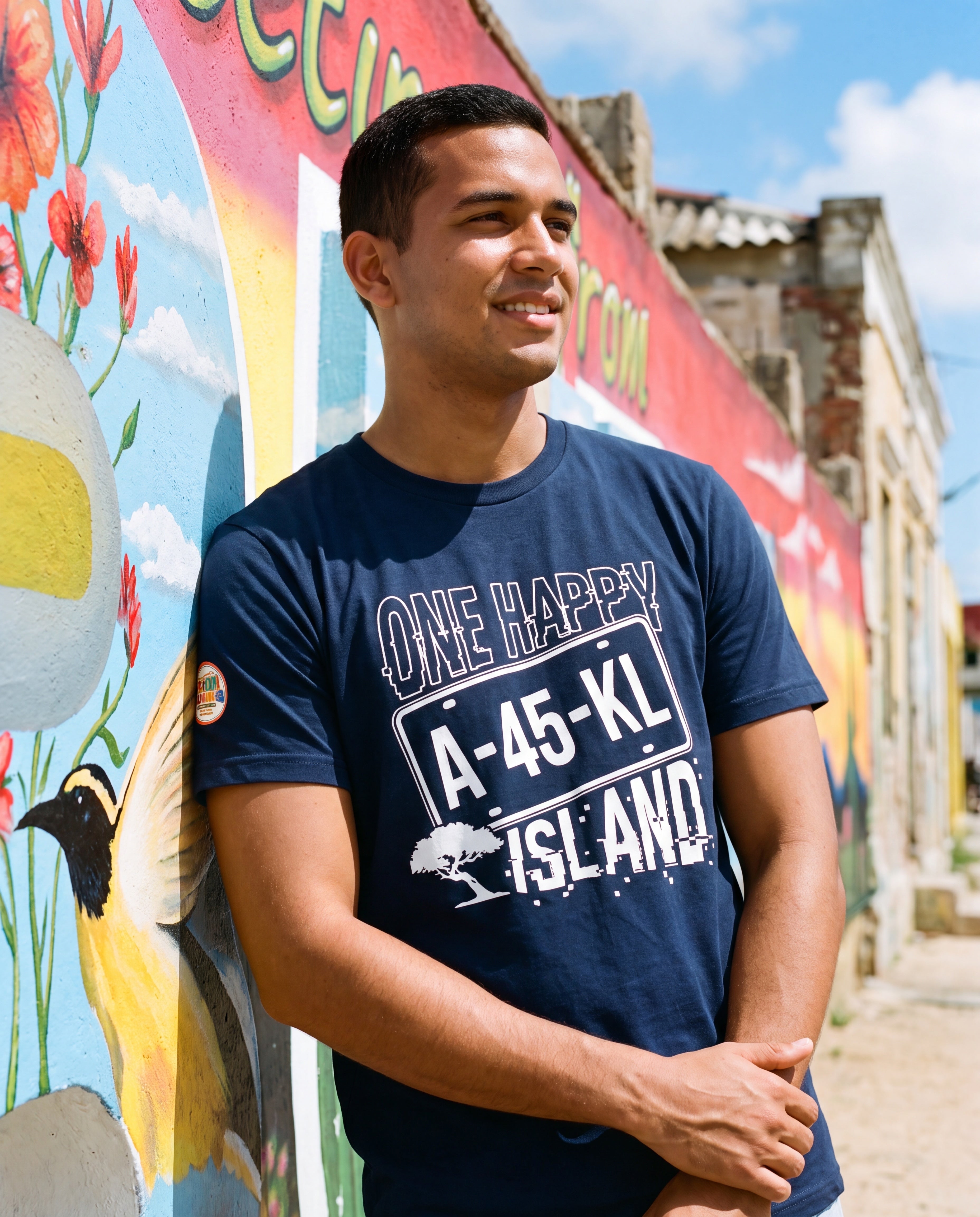Man wearing the One Happy Island License Plate Tee in San Nicolas, Aruba