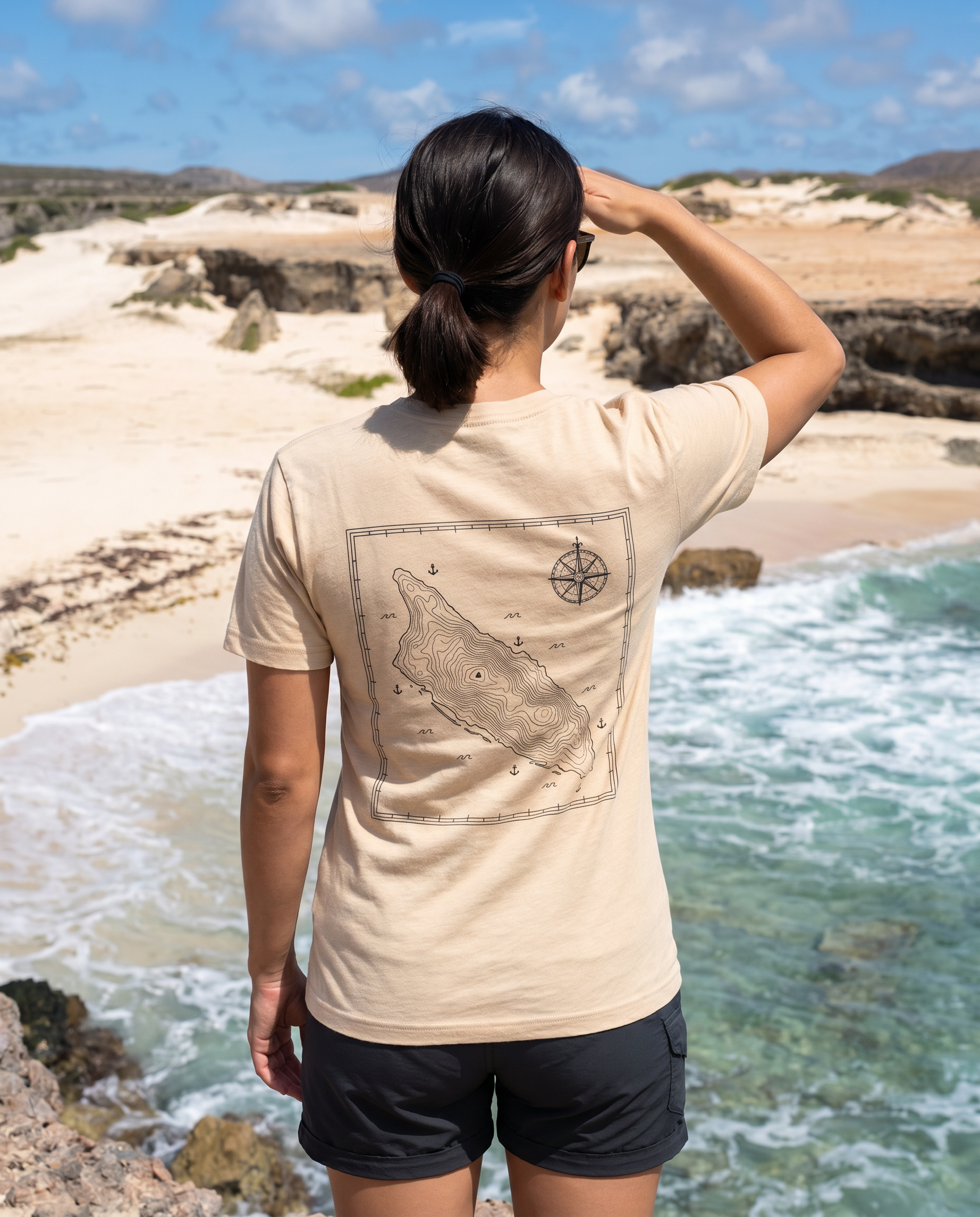 Aruba Topographic Map Tee in Heather Sand Dune, worn on the Arikok National Park coast, Aruba (back print)