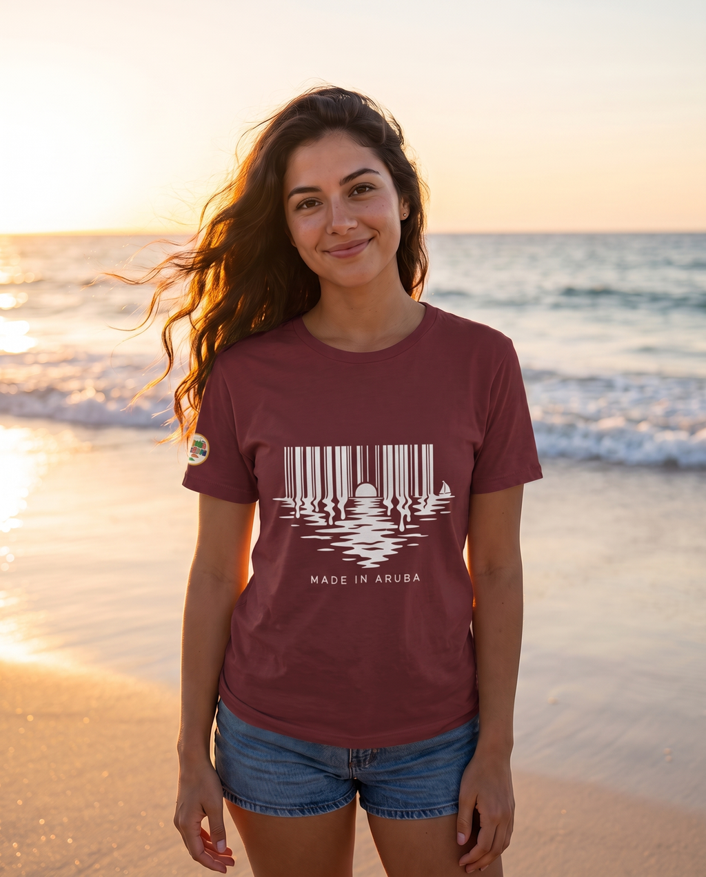 Made in Aruba Barcode Sunset Tee in Maroon, worn at golden hour on Eagle Beach, Aruba