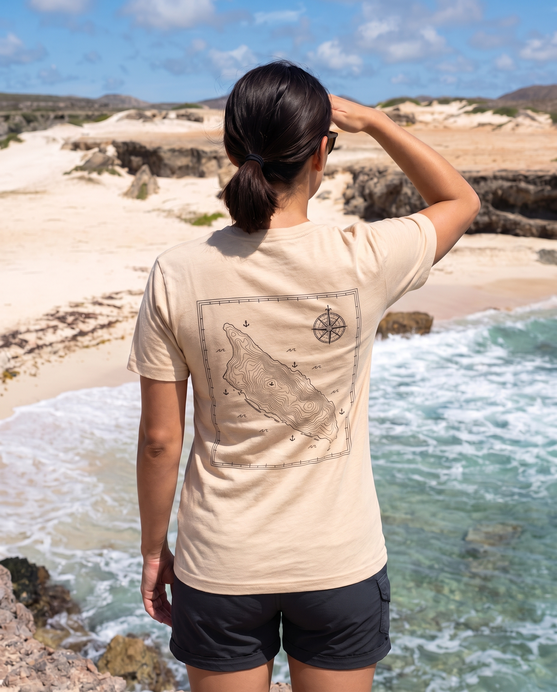 Aruba Topographic Map Tee in Soft Cream, worn on the Arikok National Park coast, Aruba (back print)