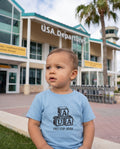 Aruba AUA First Stop Baby Blocks Tee in Light Blue, worn on location in Aruba