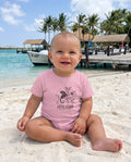 Aruba Little Lizard Hibiscus Baby Tee in Pink, worn on location in Aruba