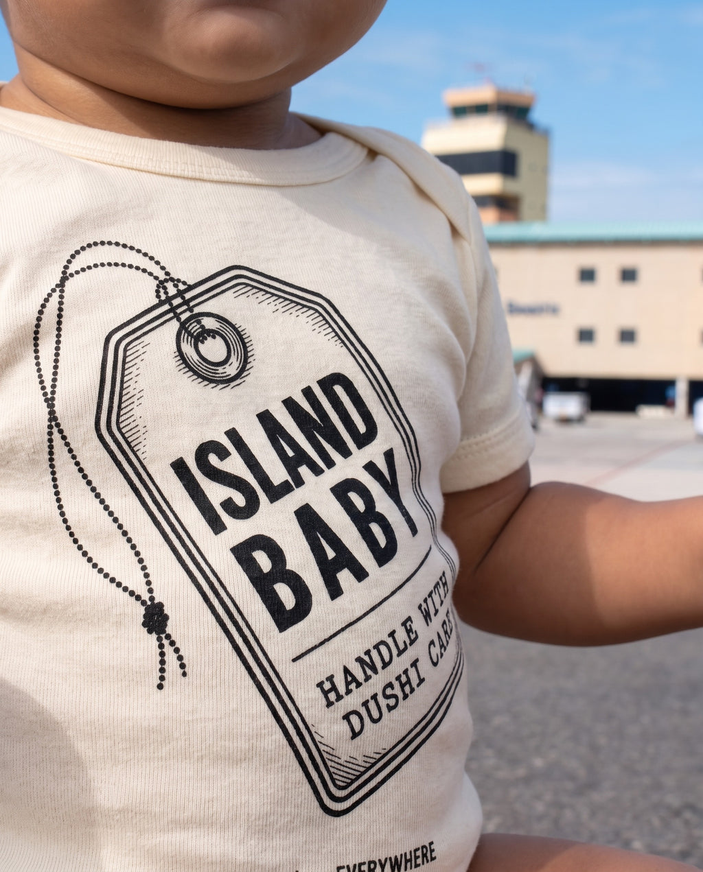 Aruba Island Baby Luggage Tag Bodysuit close-up of the design, Natural