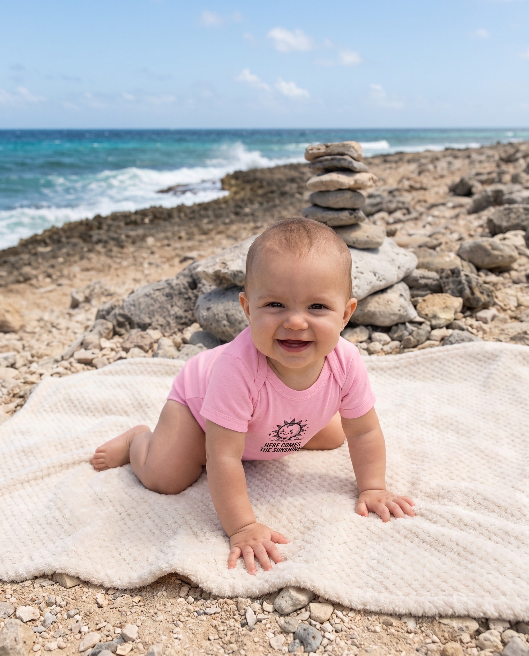 Aruba Here Comes the Sunshine Baby Bodysuit in Pink, worn on location in Aruba