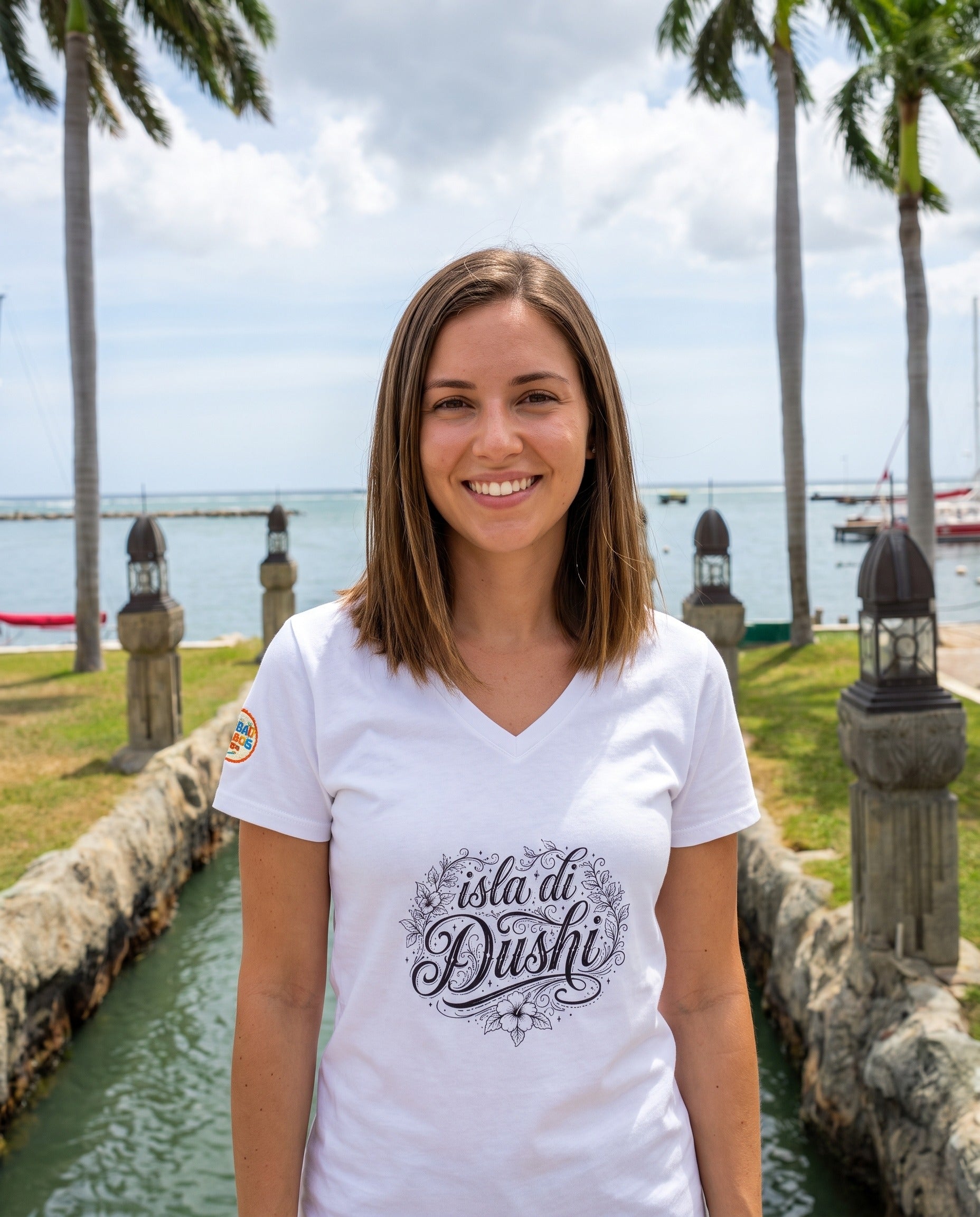 Isla di Dushi Aruba Script V-Neck Tee in Solid White Blend, worn on location in Aruba
